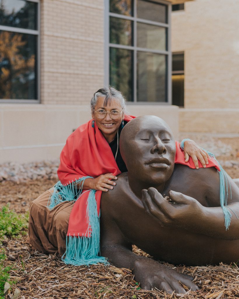 Artist Roxanne Swentzell with sculpture of person